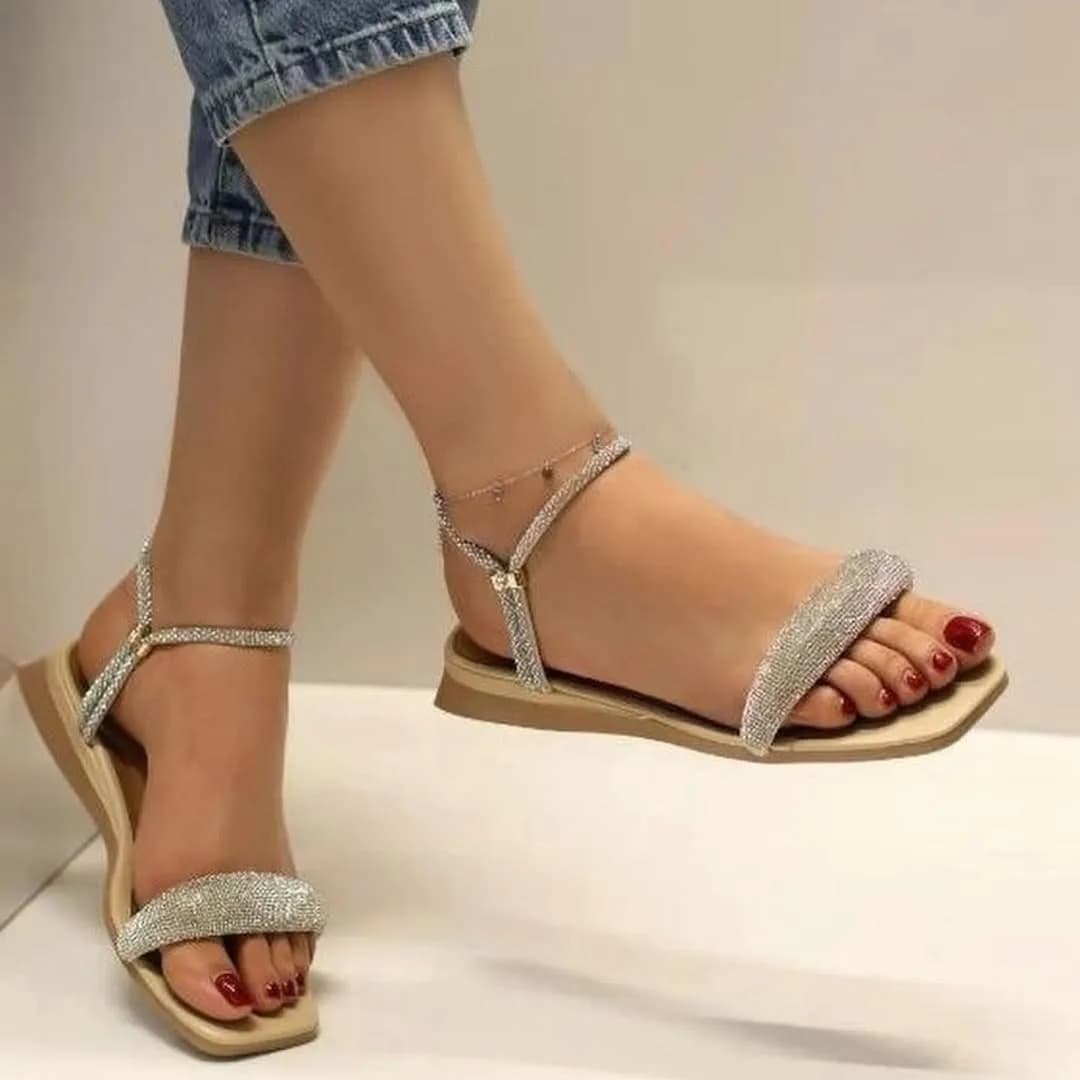 صندل زنانه کرم، رنگ نقره‌ای، جنس فلز و چرم، طرح نگین‌دار، صندل تخت بندی