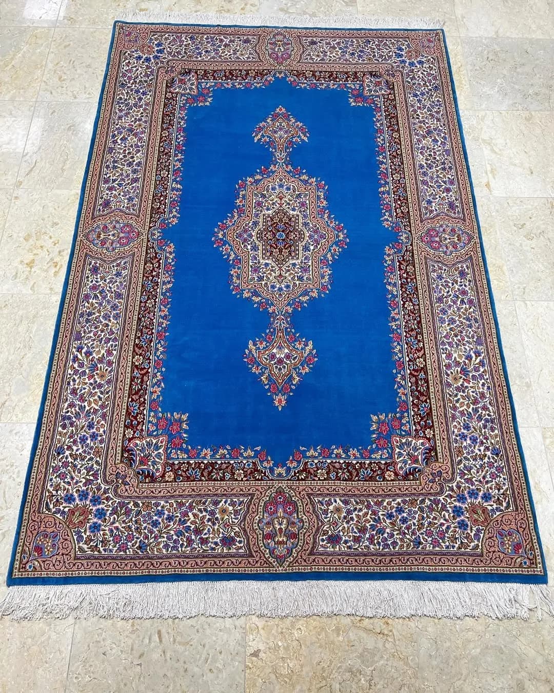 فرش ۶ متری کف ساده حاشیه گلباران کرمان، رنگ آبی و سرمه‌ای، جنس نخ، طرح گلدار، مستطیل، کلاسیک