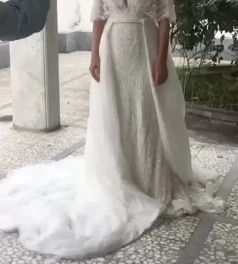 لباس عروس مدل ماهی با دنباله جدا مزون هستی، رنگ سفید، طرح گلدوزی، بلند، یقه وی، آستین کوتاه، جذب