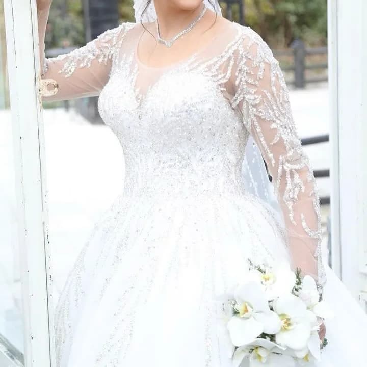 لباس عروس سایز ۳۸ تا ۴۲ مزون هستی، رنگ سفید، جنس توری، طرح گلدوزی، بلند، آستین بلند، یقه قلبی