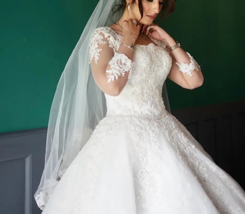 لباس عروس سنگدوزی سایز ۳۶ تا ۴۰ هستی، رنگ سفید، جنس تور و گیپور، بلند، یقه دکلته، آستین بلند، پفی