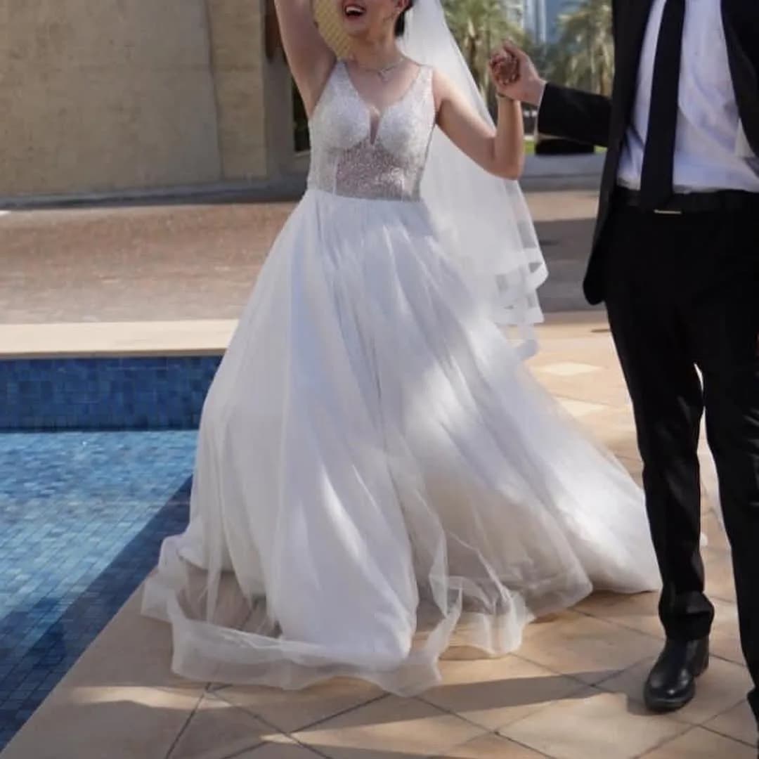 لباس عروس سایز ۳۶ و ۳۸، رنگ سفید، جنس توری و ساتن، طرح گلدوزی، بلند، یقه وی، بدون آستین، گشاد