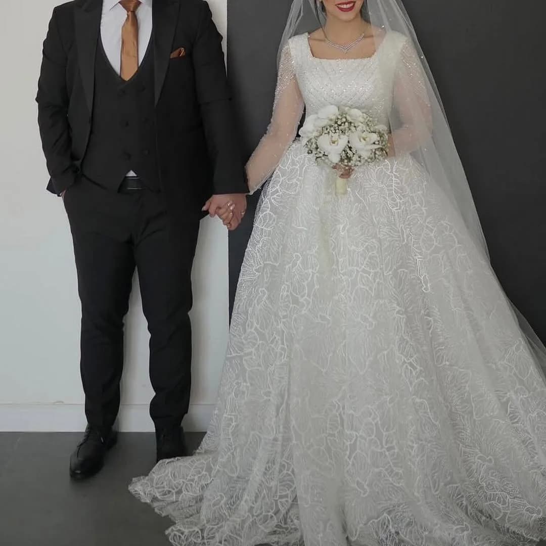لباس عروس مزوندوز با ژپون ۵ فنره، رنگ سفید، جنس توری، طرح گلدوزی، بلند، آستین بلند، کلوش