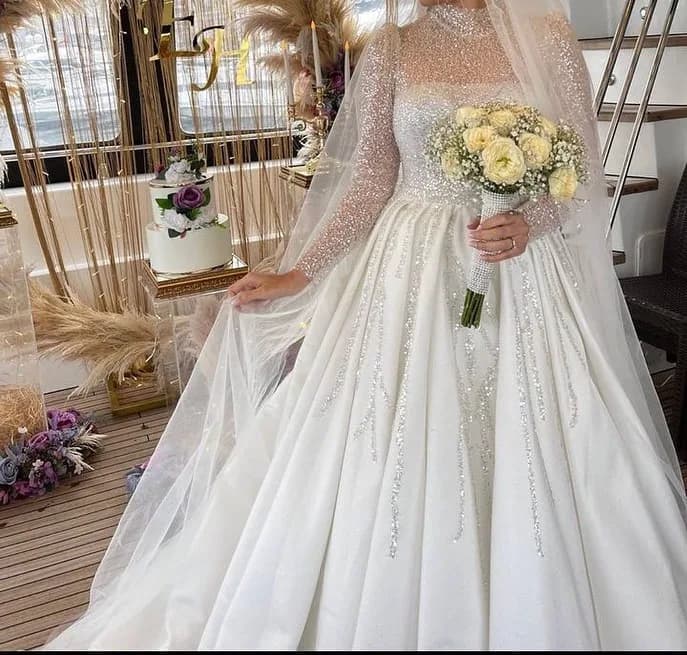 لباس عروس ترک سایز ۳۴ تا ۳۸، رنگ سفید، جنس پولکدوزی و تور، طرح سنگدوزی، بلند، یقه ایستاده، آستین بلند، جذب