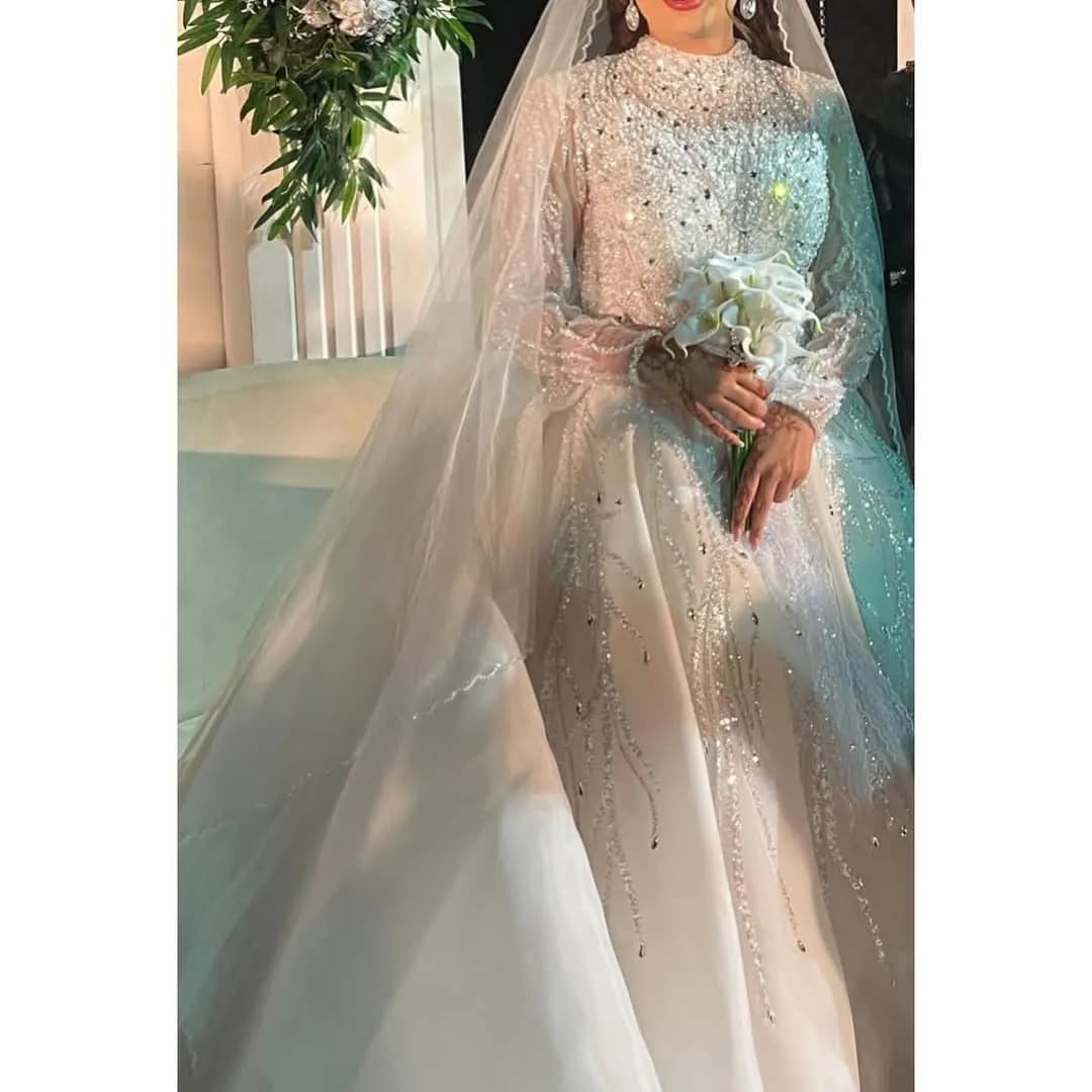 لباس عروس سنگ‌دوزی سایز ۳۸ تا ۴۰، رنگ سفید، جنس ساتن و تور، بلند، یقه ایستاده، آستین‌بلند