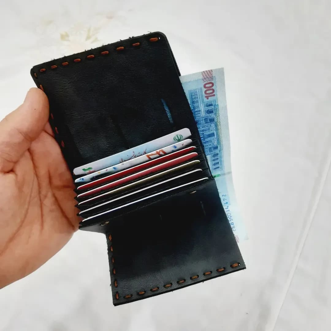 کیف پول چرم دست‌دوز — رنگ مشکی — نمای در‌دست — دست‌دوز