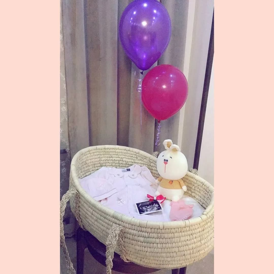 گهواره نوزاد، رنگ کرم، صورتی و بنفش، جنس حصیری و پارچه، پایهدار گهوارهای