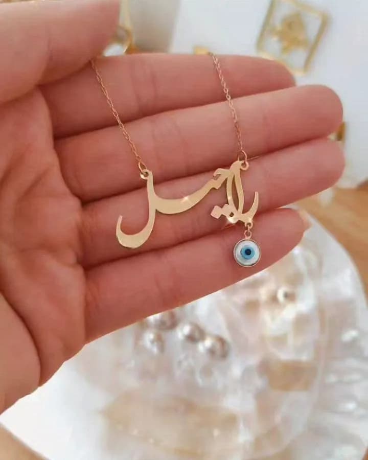 گردنبند اسم راحیل نستعلیق دورتا، رنگ طلایی، جنس طلا و شیشه، پلاک اسم و چشم نظر
