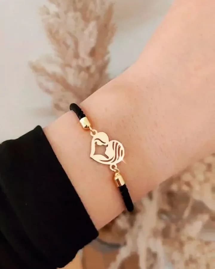 دستبند طلا طرح مادر و کودک با بند مارشال، رنگ طلایی و مشکی، جنس فلز و نخ، بندی با پلاک قلبی