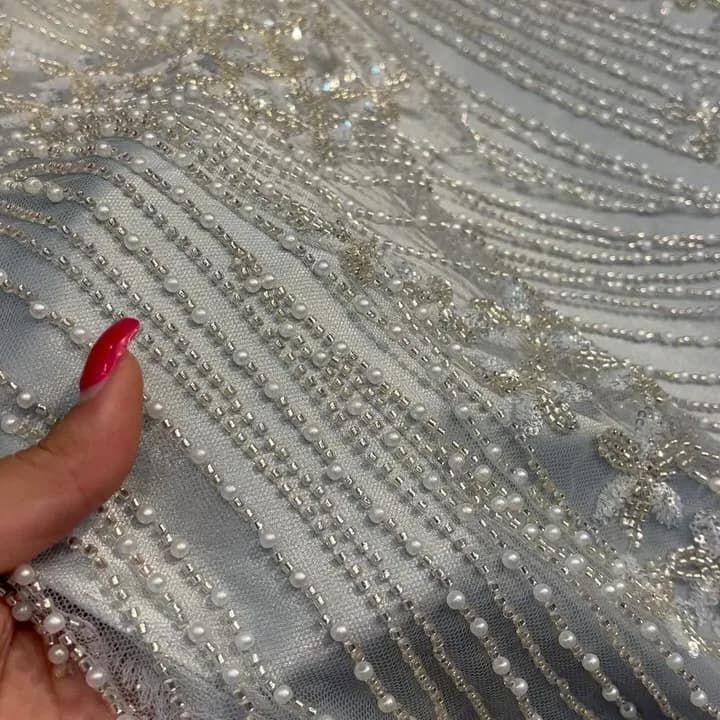 پارچه سنگ‌دوزی عرض ۱۳۵، رنگ سفید و نقره‌ای، جنس توری، طرح گلدوزی، پارچه مجلسی