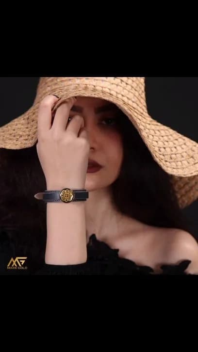 دستبند چرم گاوی با پلاک روکش طلا، رنگ مشکی و طلایی، جنس فلز، طرح هندسی، بند چرمی با مهره وسط