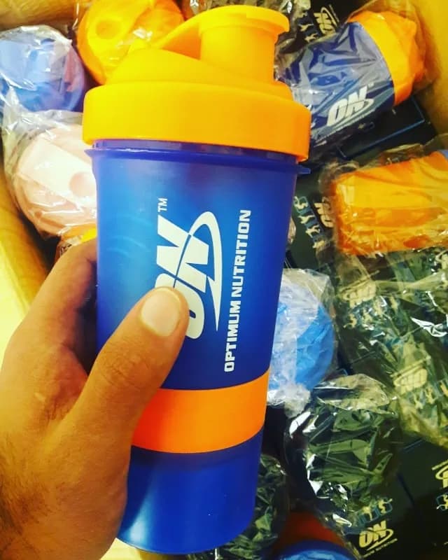 شیکر سه تیکه اپتیمم، رنگ آبی و نارنجی، جنس پلاستیک، استوانه‌ای، درب‌دار