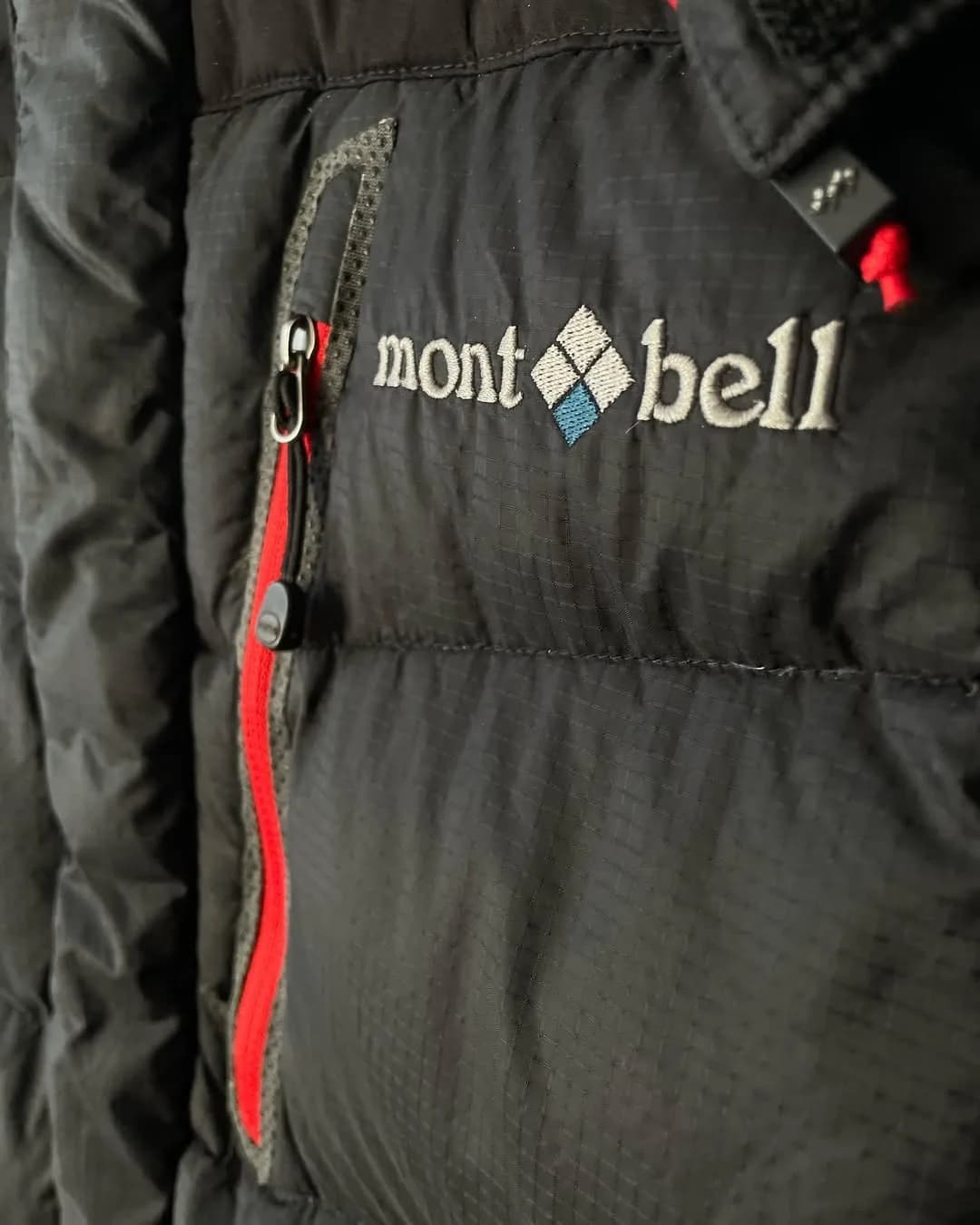 کاپشن Mont-bell، رنگ مشکی و قرمز، جنس پلاستیک، کوتاه جیبدار زیپدار