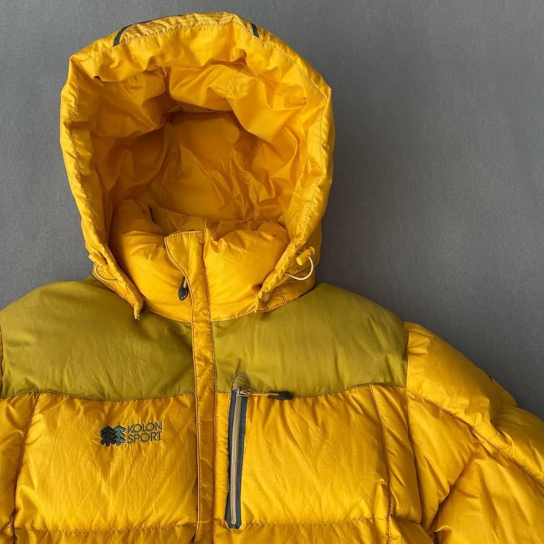 کاپشن پارچه وینداستاپر Kolon Sport، رنگ زرد، کلاهدار، پافر