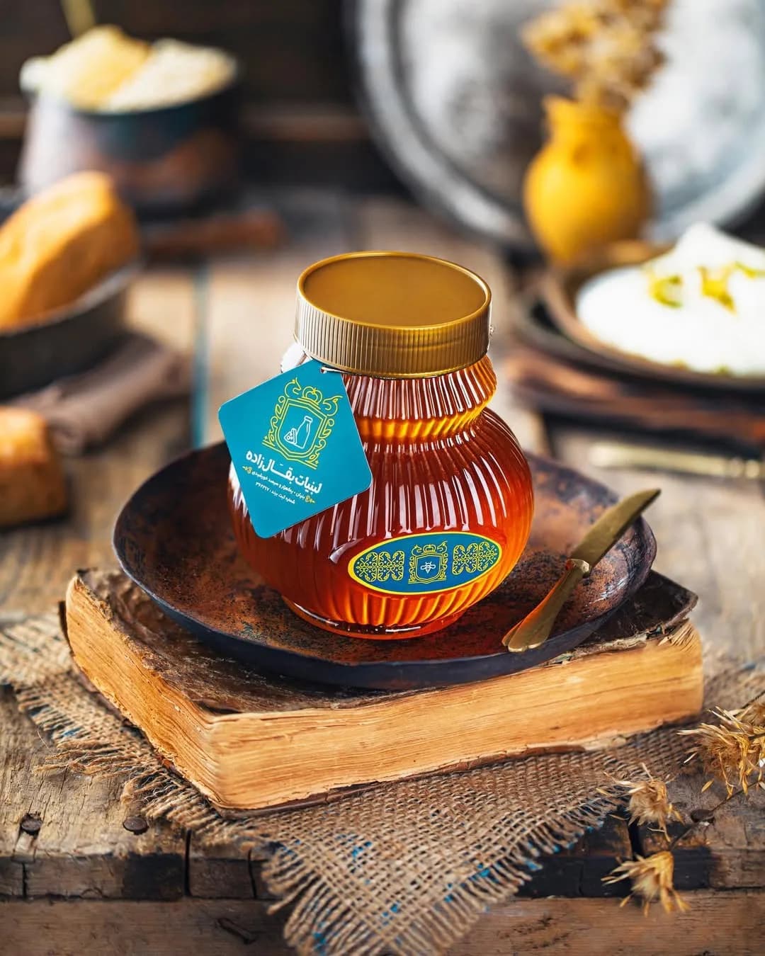 عسل طبیعی بقالزاده، رنگ کهربایی و طلایی، جنس شیشه و فلز، ظرف دردار