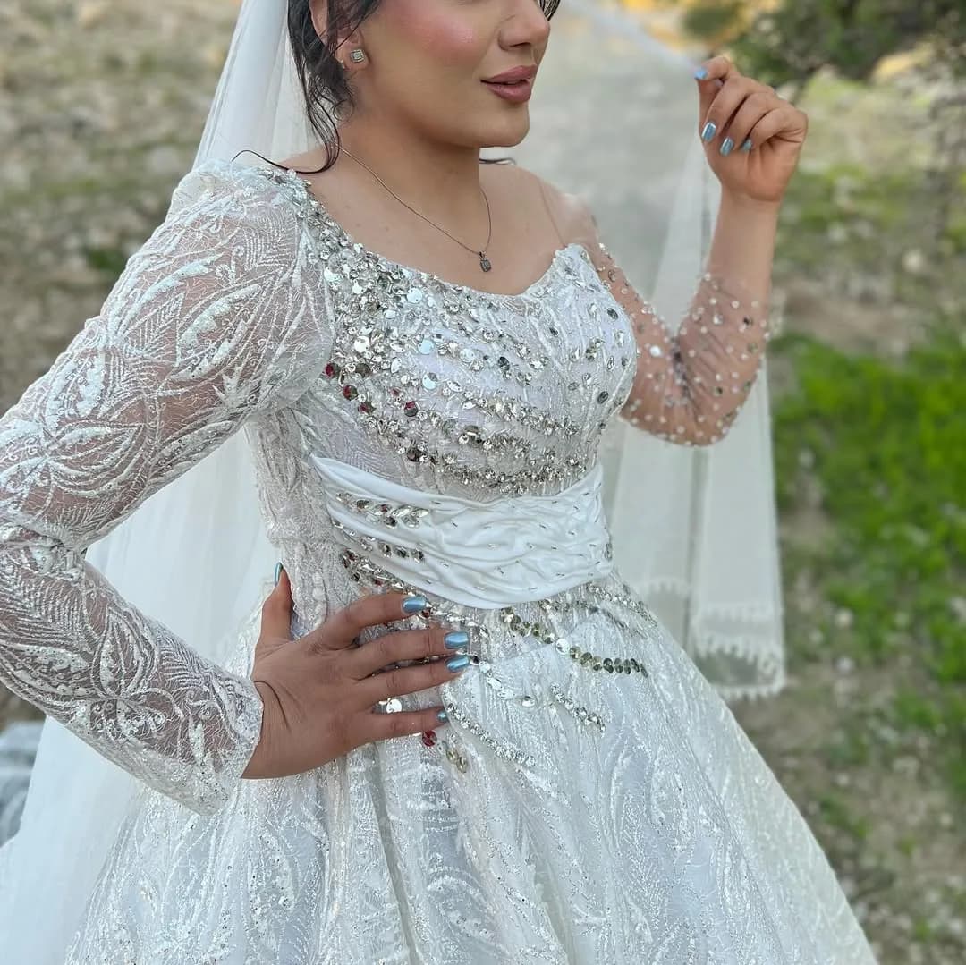 لباس عروس مدل رومی سنگدوزی، رنگ سفید، جنس توری، طرح گلدوزی، آستین بلند، یقه قلبی، پفدار