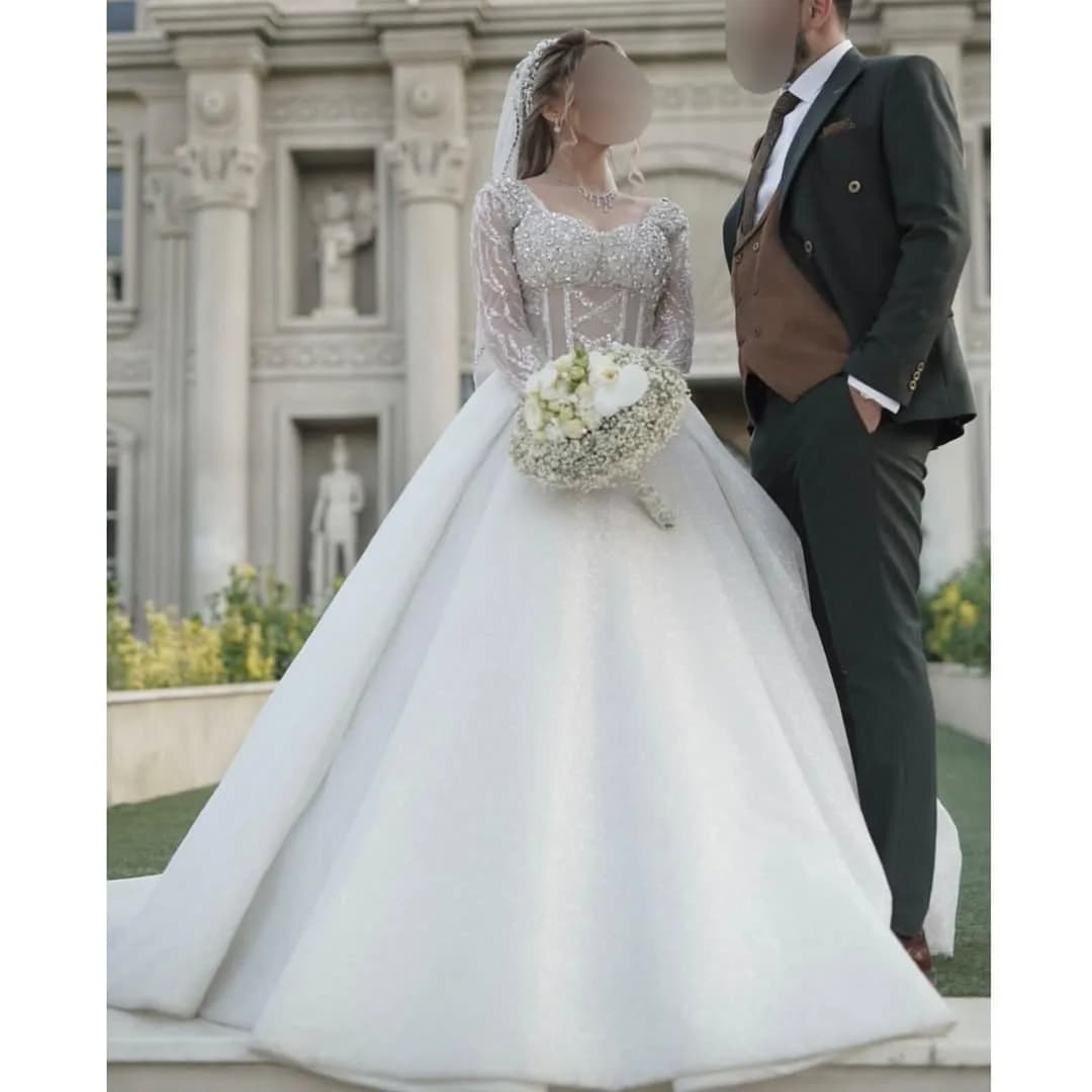 لباس عروس بالاتنه سنگدوزی سایز ۳۸ تا ۴۰، رنگ سفید، جنس توری و ساتن، طرح گلدوزی، بلند، آستین بلند، پفدار