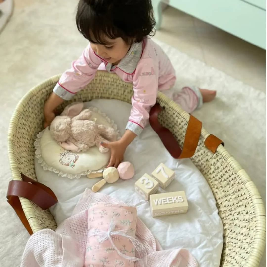 سبد حصیری حمل نوزاد، رنگ کرمی، سفید و صورتی، جنس چوب و پارچه، سبد با پایهی چوبی