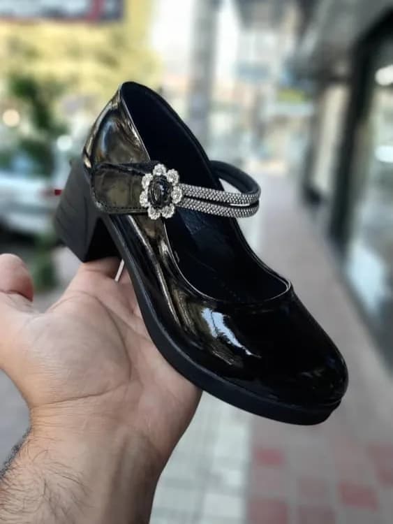 کفش مجلسی بچگانه، رنگ مشکی و نقرهای، جنس چرم، پاشنه متوسط، بنددار
