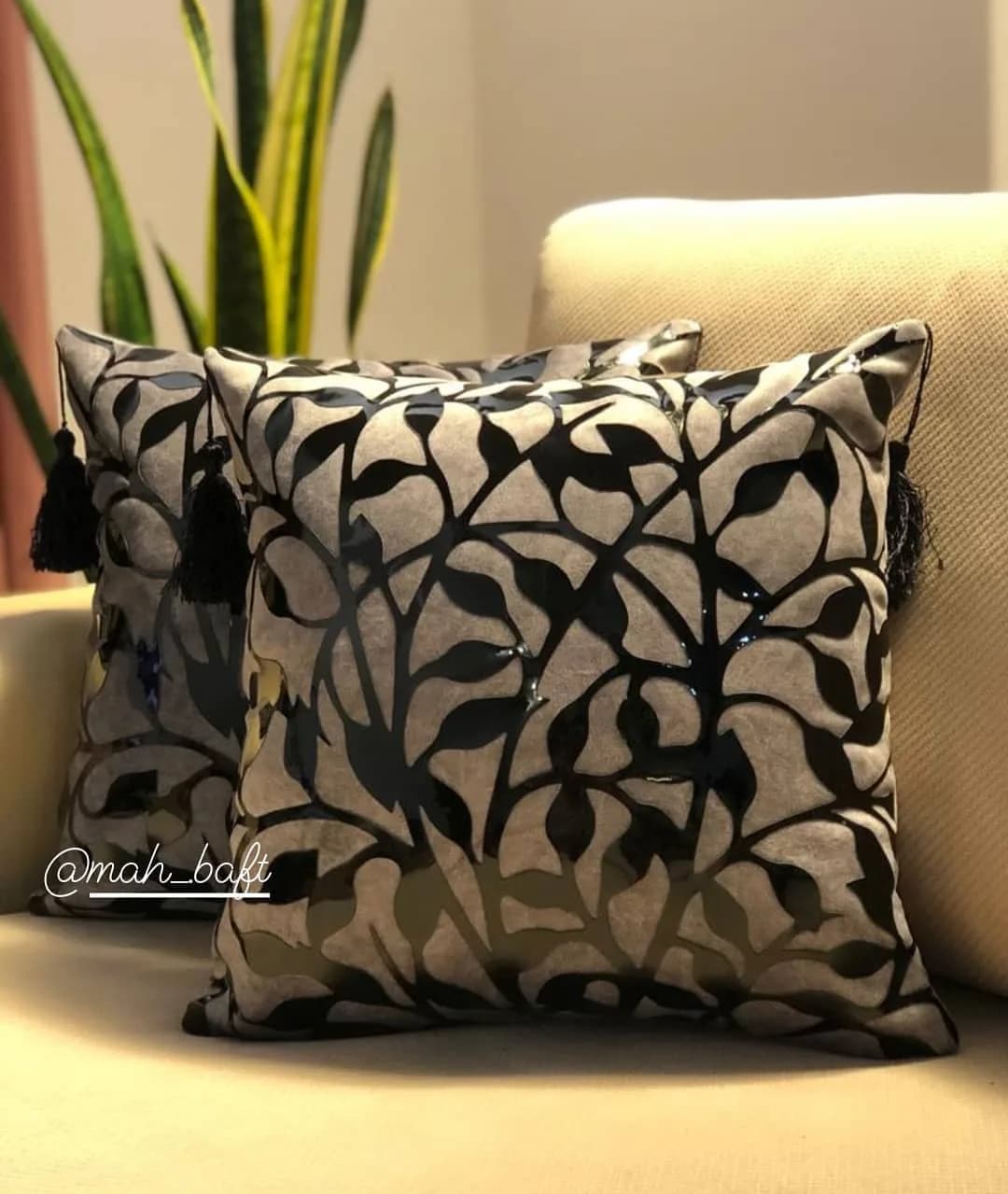 کوسن طرح شاخ و برگ طوسی، رنگ خاکستری و مشکی، جنس مخمل، طرح گلدار، مربع، با منگوله