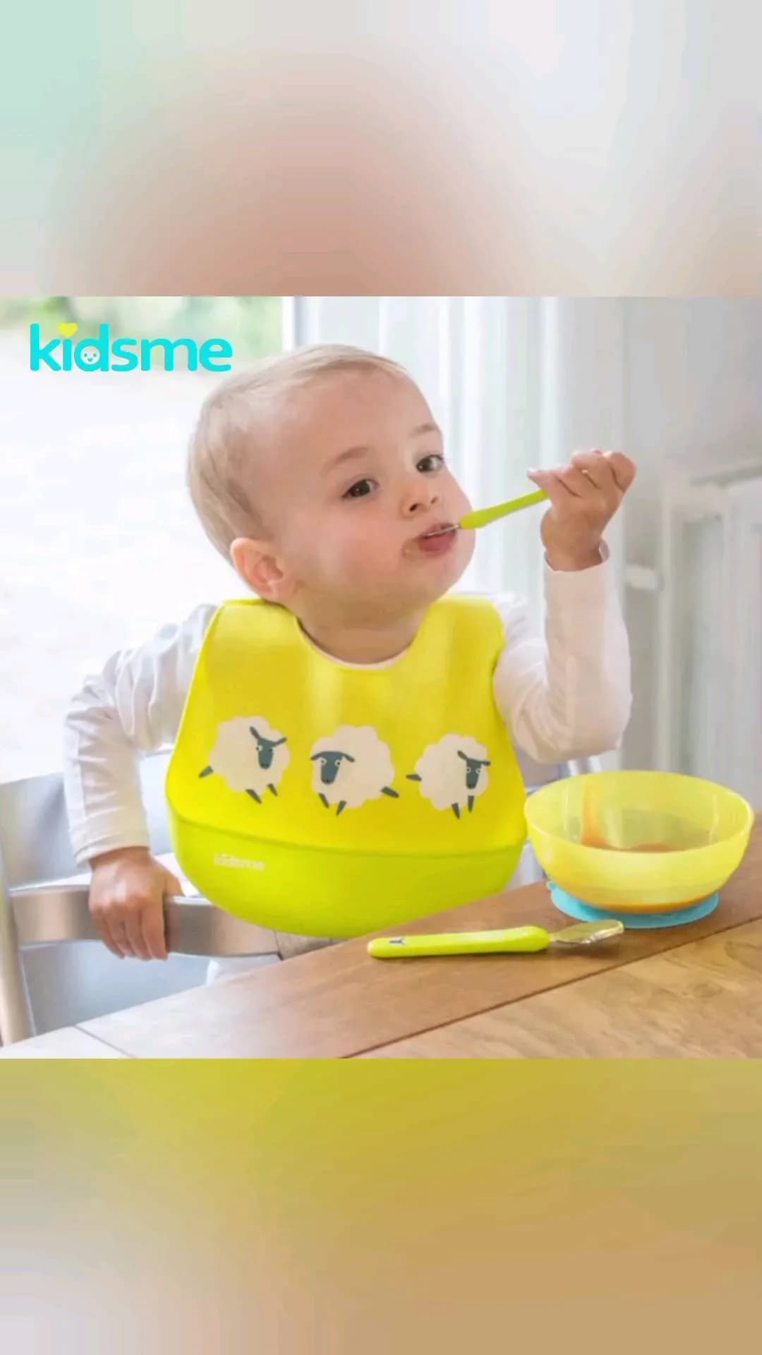 پیشبند سیلیکونی نوزاد با قاشق و چنگال کیدزمی، رنگ زرد، طرح شخصیت کارتونی، دارای جیب