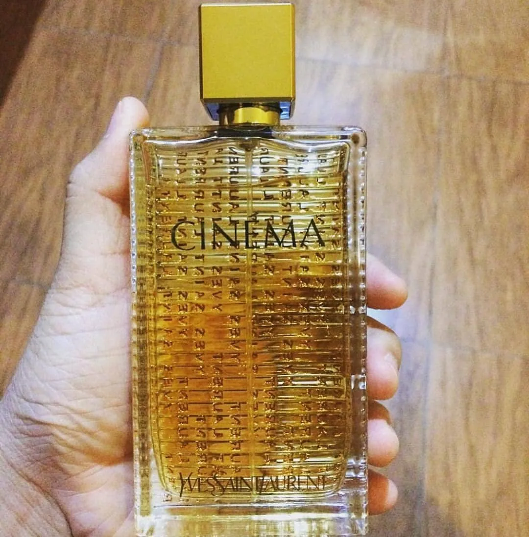 عطر زنانه ایو سن لورن سینما، رنگ طلایی و شفاف، جنس شیشه و فلز، بطری عطر مستطیلی
