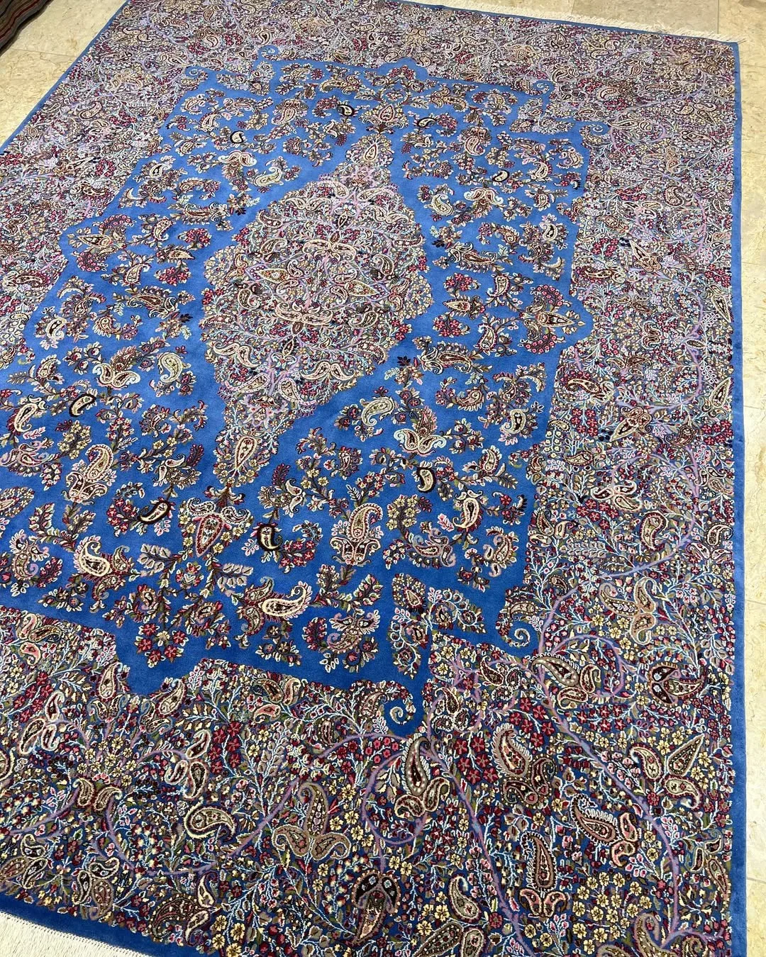 فرش نه متری فیروزه‌ای پته یاسایی کرمان، رنگ آبی و قرمز، طرح گلدار، مستطیلی