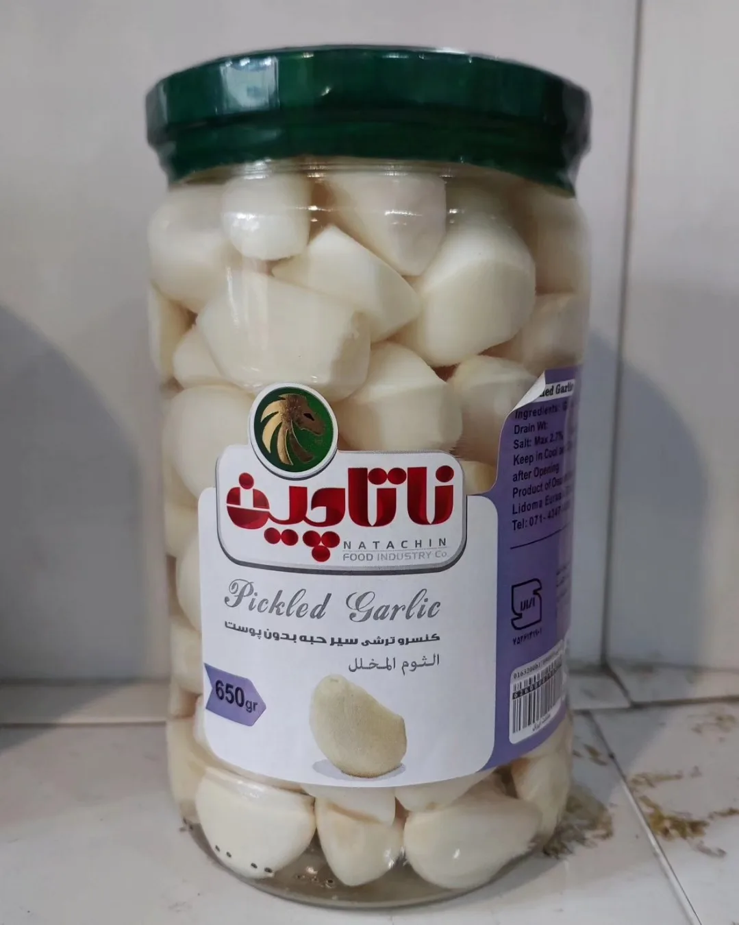 ترشی سیر مروارید ناتاچین، رنگ سفید و سبز، جنس شیشه، ظرف شیشه‌ای استوانه‌ای دردار