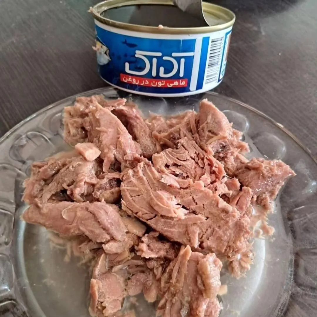 تن ماهی آداک ۱۸۰ گرمی، رنگ صورتی مایل به قهوهای و آبی، جنس فلز، قوطی استوانهای