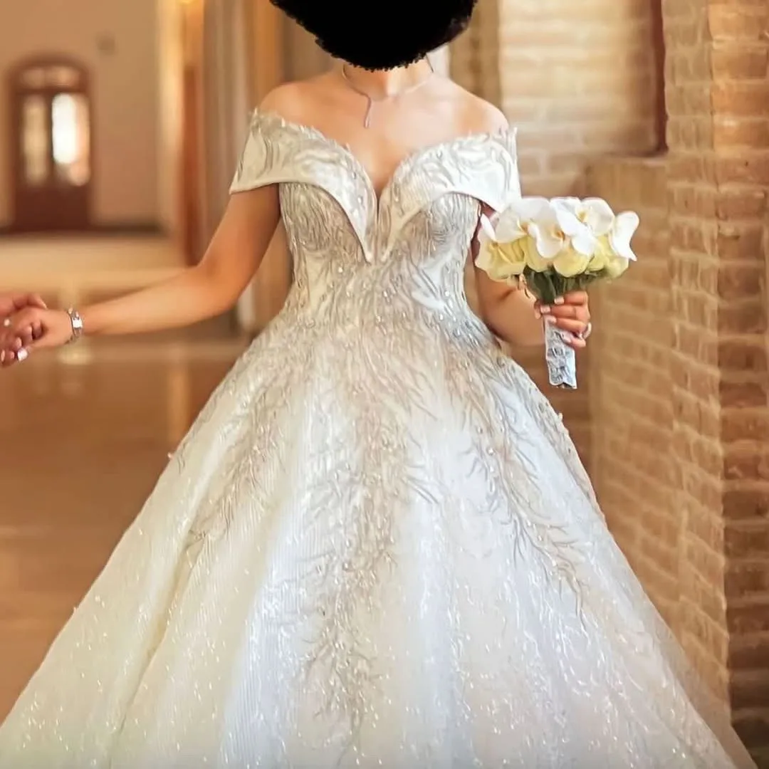لباس عروس تور و شاین دنباله‌دار، رنگ سفید، جنس ساتن، طرح گلدوزی، بلند، یقه دکلته، آستین کوتاه