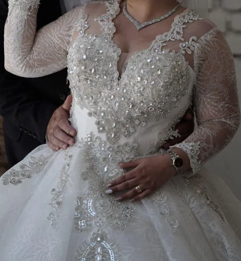 لباس عروس مزون‌دوز دنباله‌دار، رنگ سفید، جنس توری، طرح گلدوزی، یقه وی، آستین بلند، جذب