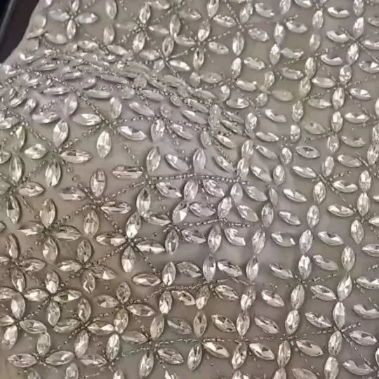 لباس عروس پارچه استری، رنگ نقره‌ای و سفید، جنس تور و پولک‌دوزی، طرح سنگ‌دوزی، بلند، یقه دکلته، آستین بلند