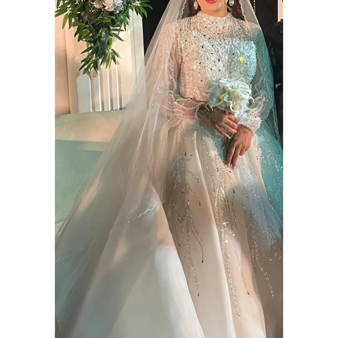 لباس عروس سنگ‌دوزی سایز ۳۸ تا ۴۰، رنگ سفید، جنس ساتن و تور، بلند، یقه ایستاده، آستین‌بلند