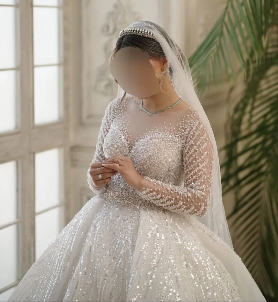 لباس عروس، رنگ سفید، جنس ساتن و تور، طرح سنگ‌دوزی، بلند، یقه گرد، آستین بلند، جذب