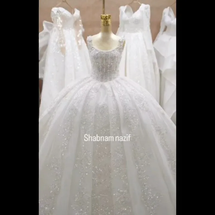 لباس عروس مرواریددوزی، رنگ سفید، جنس تور و ساتن، طرح سنگ‌دوزی، بلند، یقه گرد، بدون آستین