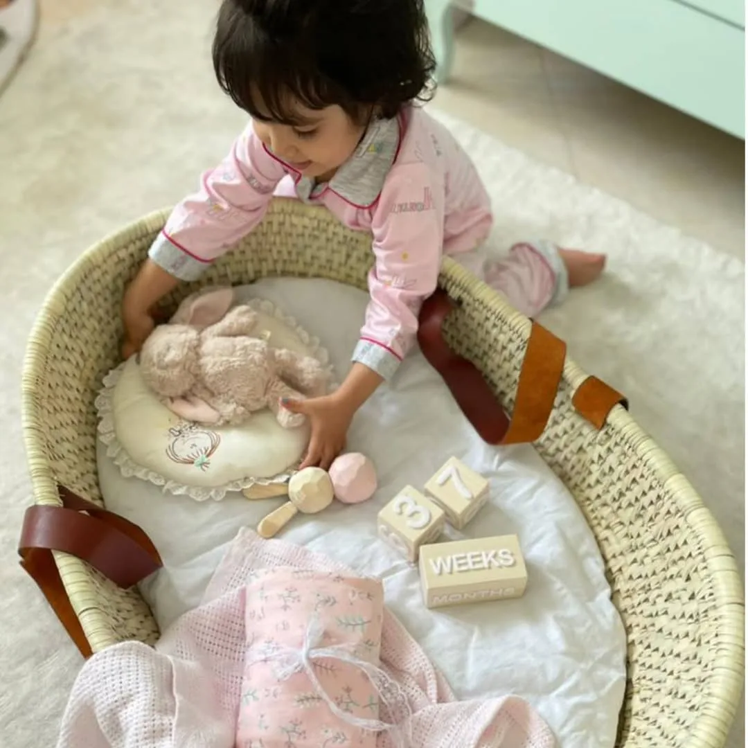 سبد حصیری حمل نوزاد، رنگ کرمی، سفید و صورتی، جنس چوب و پارچه، سبد با پایه‌ی چوبی
