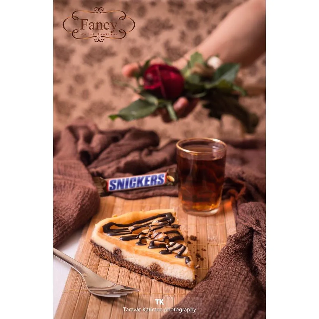 چیزکیک اسنیکرز، رنگ کرم و قهوهای، مثلثی، تک تکه