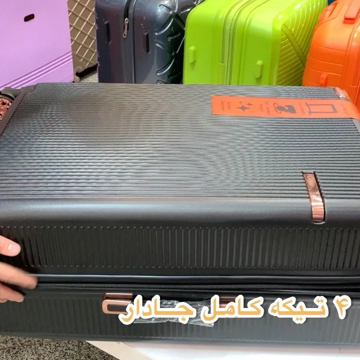 چمدان چهارتکه، رنگ خاکستری تیره، جنس پلاستیک، سخت، چرخ‌دار، دسته‌دار
