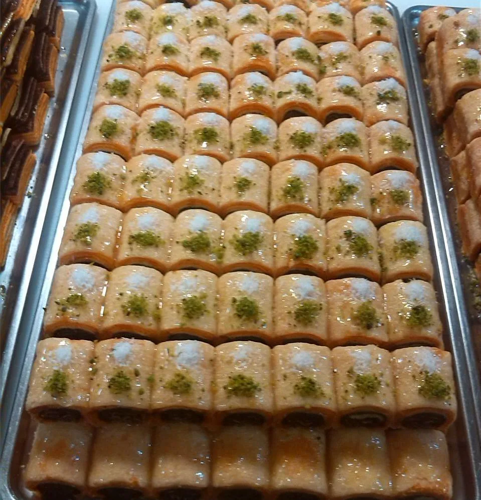 شیرینی سنتی با پسته، رنگ کرم و سبز، استوانه‌ای برش‌خورده
