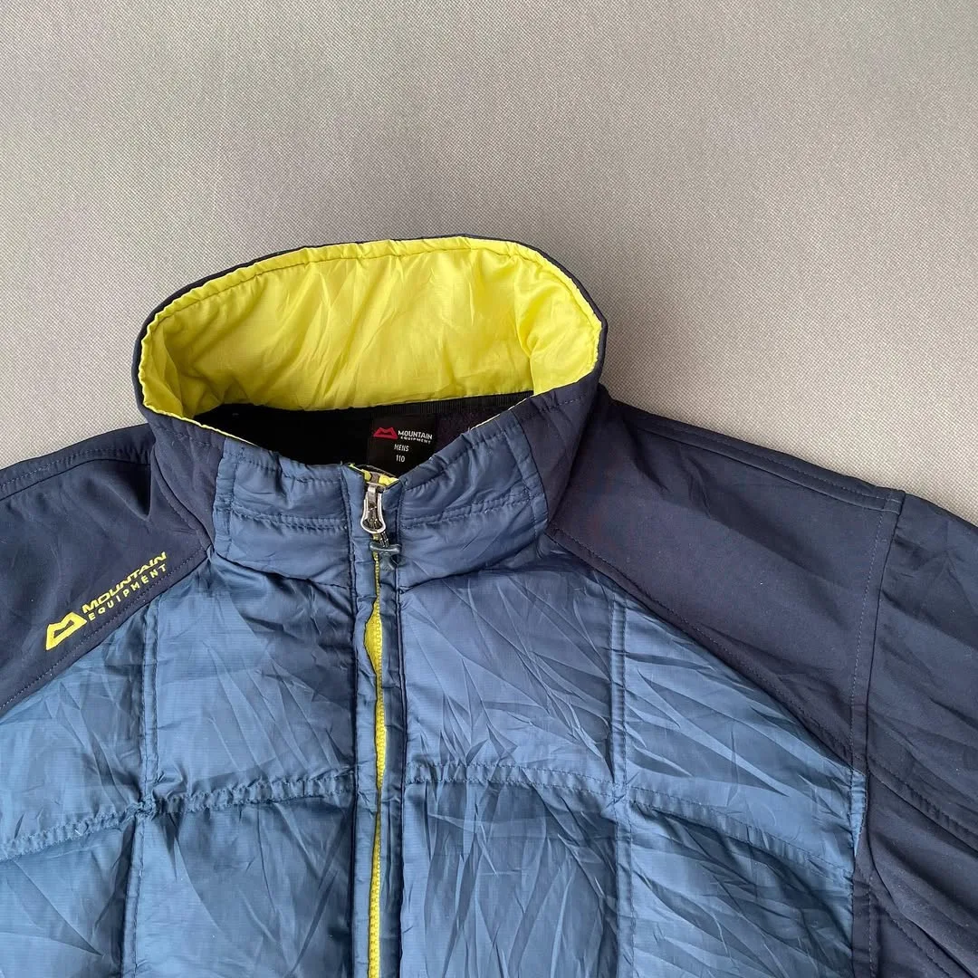 کاپشن ترکیبی پر و پلار سایز ۱۱۰ Mountain Equipment، رنگ سرمه‌ای و زرد، جنس پلاستیک، کوتاه یقه ایستاده آستین بلند